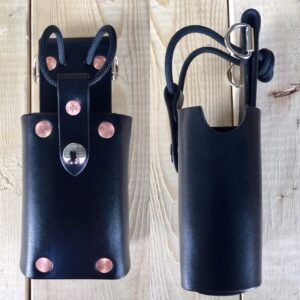 Black leather tool holster on wood background.