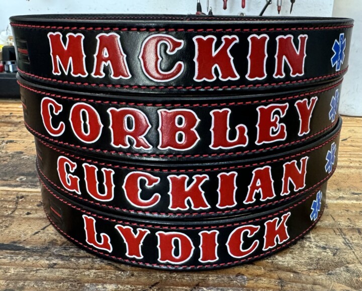 Custom black belts with red names stacked.