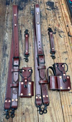 Leather straps and holsters on a wooden surface.