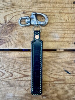 Leather keychain with metal clasp on wood.